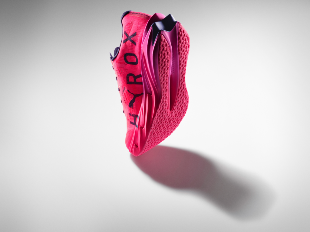 Angled view of the purple and pink Puma HYROX competition footwear, displaying the sleek design and technical branding for the 2026 season
