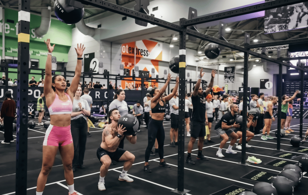 Professional sports photography of athletes following hyrox wall ball weights rules at station 8 in a row
